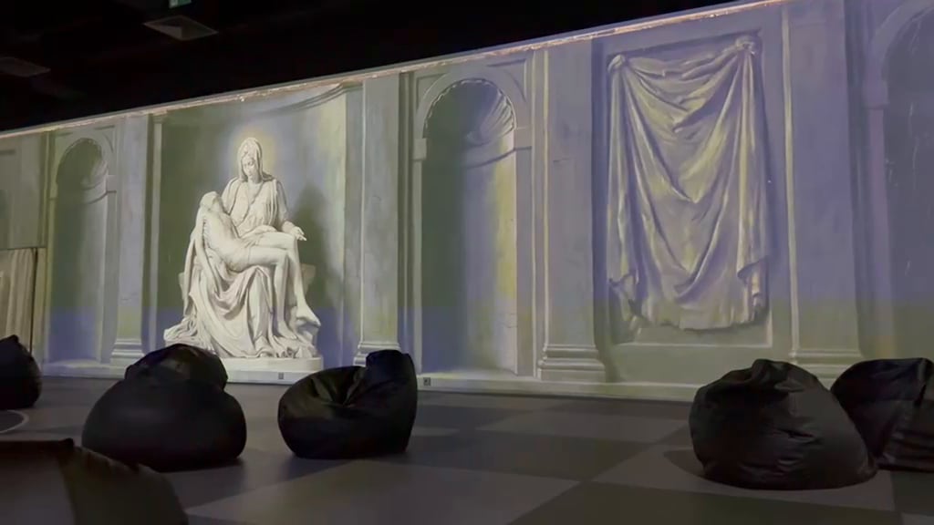 Pietà Michała Anioła w jasnej sali z pufami