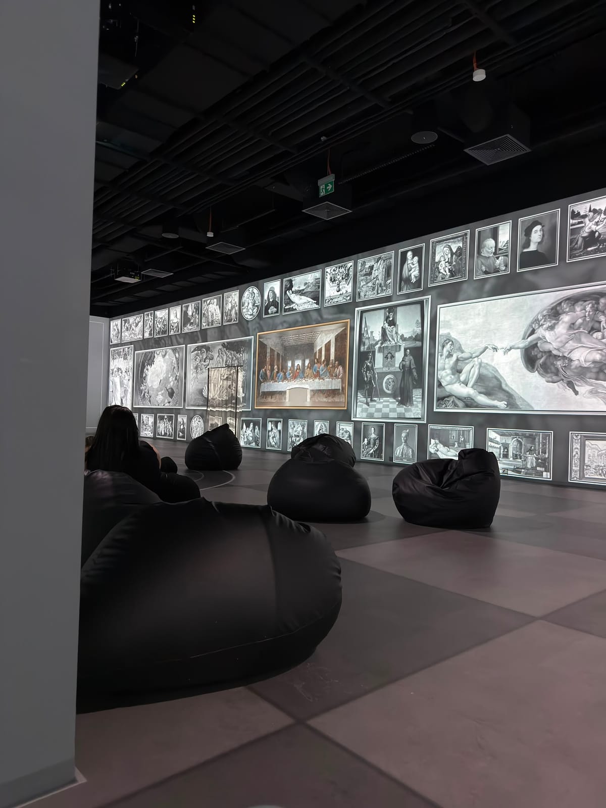 Widzowie na pufach przed galerią obrazów